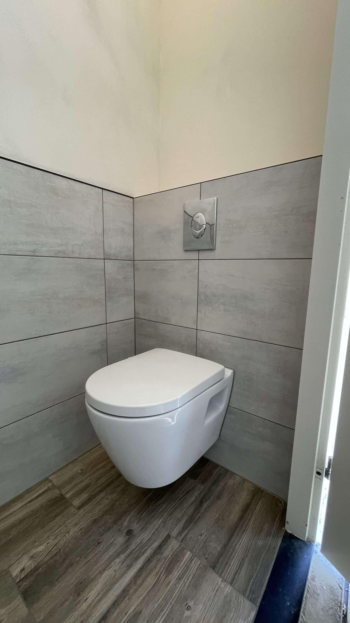 Portfolio Toiletrenovatie in uitvoering: inbouwframe geplaatst, deels betegeld en wanden gestuukt door NJB Klussen